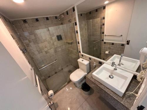 a bathroom with a toilet and a sink and a shower at Flat no hotel jatiúca suítes Resort in Maceió