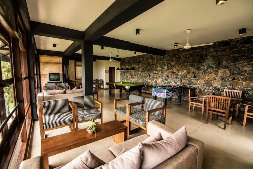 ein Wohnzimmer mit Sofas und einem Billardtisch in der Unterkunft Melheim Resort and Spa in Haputale