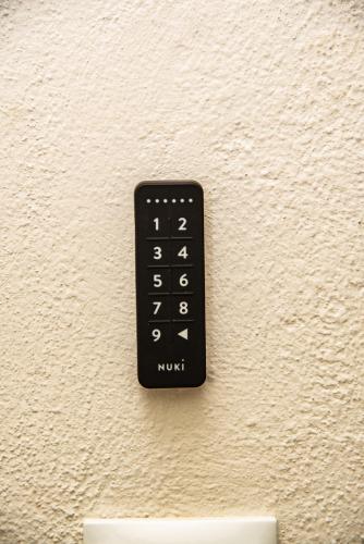 a black remote control on a white wall at Serenity by Elite Dwellings in Portariá