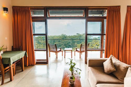 een woonkamer met een bank en een groot raam bij Melheim Resort and Spa in Haputale