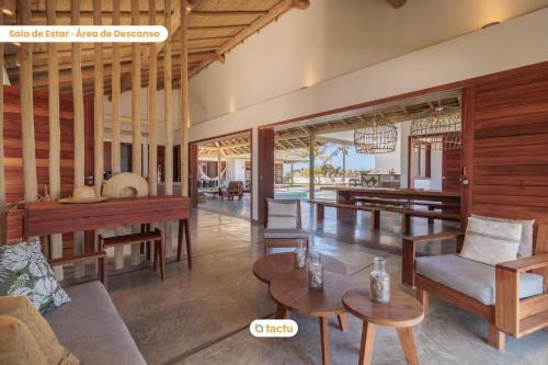 a living room with wooden furniture and a table at Vila Oásis no Pontal do Maceió Fortim Vista Mar in Fortim