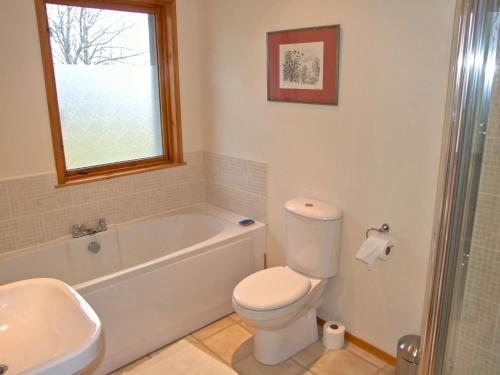 a bathroom with a toilet and a tub and a sink at Balorrin in Contin