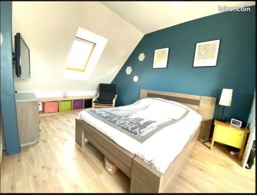 1 dormitorio con cama y pared azul en Appartement 2 chambres, en Colmar