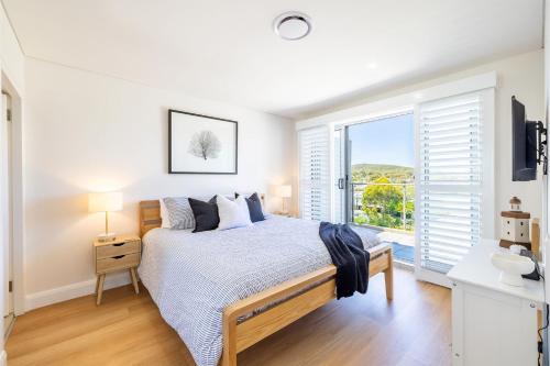a bedroom with a bed and a large window at The Shoal, 508, Bullecourt St - stunning views, air con, lift and Wi-Fi in Shoal Bay