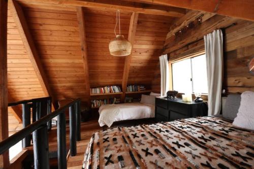 a bedroom in a log cabin with a bed and a window at Alpine Retreat: Off-Grid Cabin Winter Adventure in Pemberton