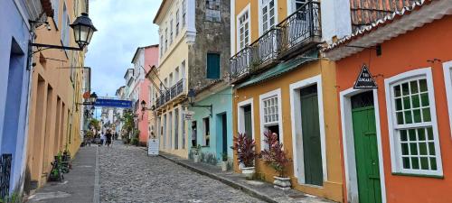 a narrow street with colorful buildings in a city at Apto com Arte no Pelourinho in Salvador
