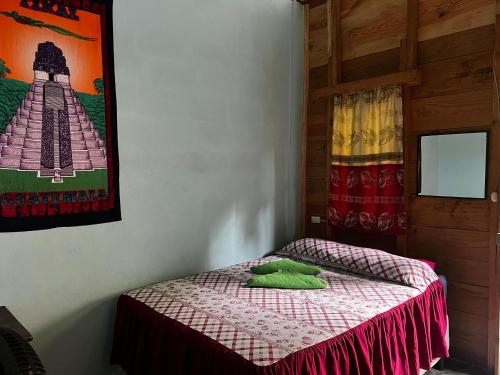 a small bed in a room with a picture on the wall at Casa " MARY " in Lanquín