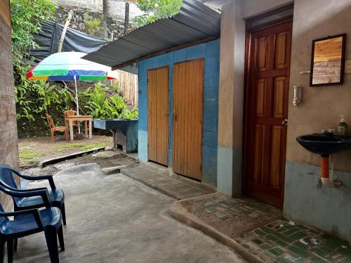a house with a door and a sink and an umbrella at Casa " MARY " in Lanquín