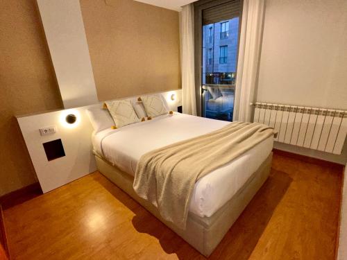 a bedroom with a large bed with a window at Apartamento Punto24 con acceso a Parking in Cáceres