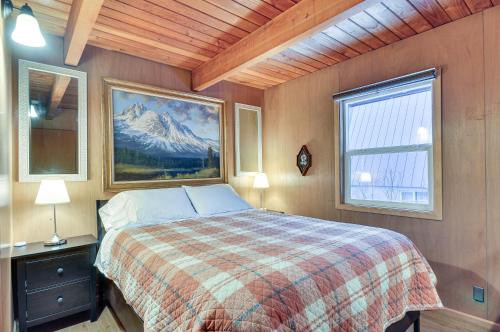 a bedroom with a bed with a mountain painting on the wall at Inviting Mt Hood Cabin with Porch 1 Mi to Skibowl! in Government Camp