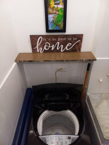 a toilet in a bathroom with a sign on a shelf at Beatiful apartment in condo in Girardot