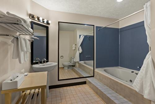 a bathroom with a tub and a toilet and a sink at Quality Inn Traverse City in Traverse City