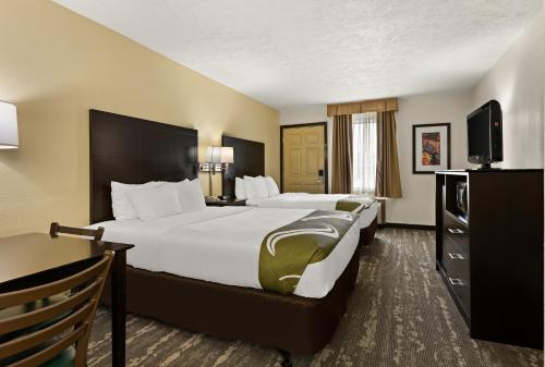 a hotel room with two beds and a flat screen tv at Quality Inn Traverse City in Traverse City