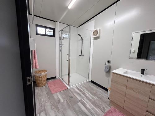 a bathroom with a shower and a sink at Feng Shui Sugarcane Cabin in Proserpine