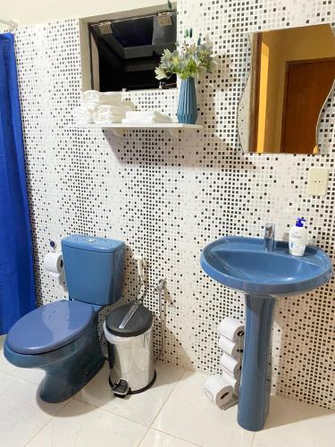 y baño con aseo azul y lavamanos. en Apartamento entero en Caacupé. en Caacupé