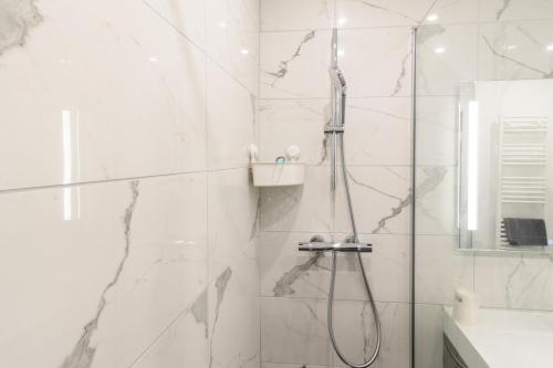 une salle de bain blanche avec une douche et un lavabo dans l'établissement Studio Disneyland RER 6 pers, à Montévrain