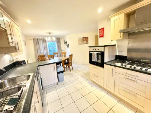 a kitchen with a sink and a counter top at 4 bedroom home just off the M20 easy access to Dover & Eurotunnel central Ashford & parking in Ashford