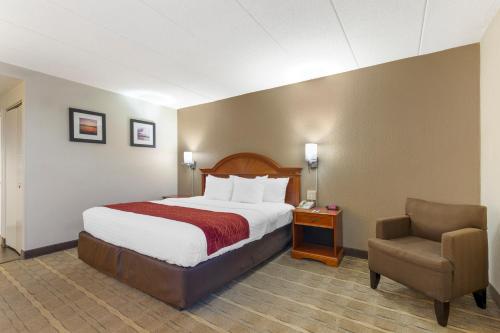 a hotel room with a bed and a chair at Comfort Inn University Center in Fairfax