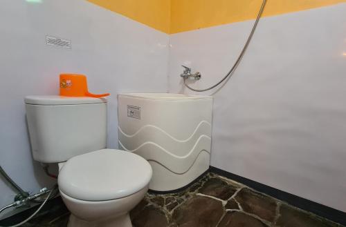 a bathroom with a toilet and a shower at Dewi Sri Guesthouse in Mataram