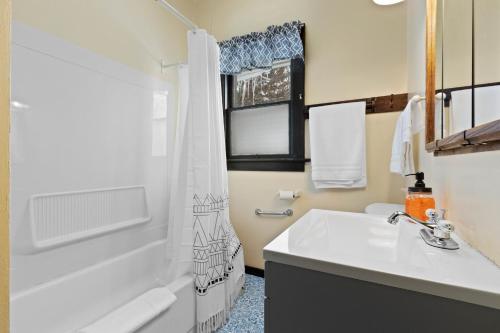 a bathroom with a sink and a toilet and a tub at Downtown Gillett Bungalow, Fireplace, 3B, Historic in Gillett