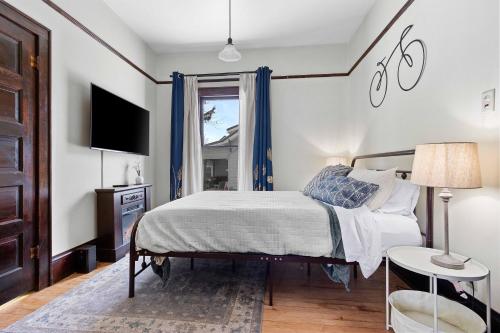 um quarto com uma cama, uma televisão e uma janela em Downtown Gillett Bungalow, Fireplace, 3B, Historic 