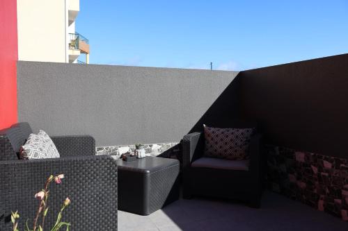 a patio with two chairs and a table at Village Center One Bedroom Apartment in Porto Moniz
