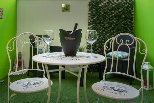 a table and two chairs with wine glasses on it at Relax room Apartment in Rome