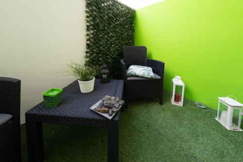 a room with a table and a chair and a green wall at Relax room Apartment in Rome