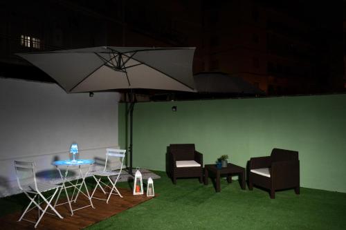a group of chairs and a table with an umbrella at Relax room Apartment in Rome