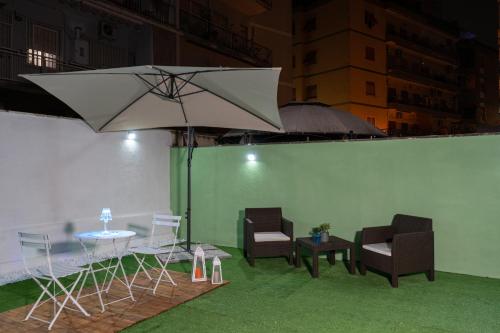 a group of chairs and a table with an umbrella at Relax room Apartment in Rome