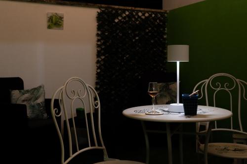 a table with a glass of wine and two chairs at Relax room Apartment in Rome