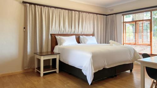 a bedroom with a large bed and a window at Kabana Family Home and Guest House in Cape Town