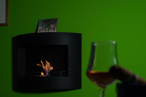 a glass of wine next to a fireplace at Relax room Apartment in Rome