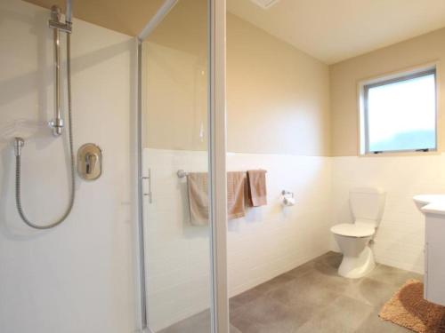 uma casa de banho com um chuveiro e um WC. em 388 Tay Motel em Invercargill