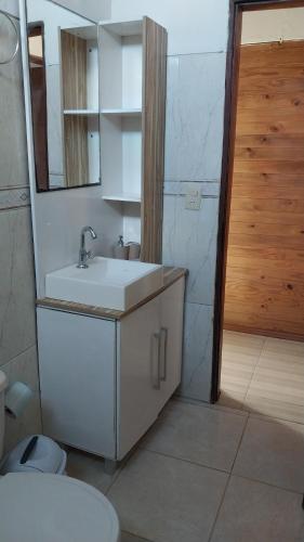 a bathroom with a sink and a mirror and a toilet at Descanso al Paso Chuy in Chuy