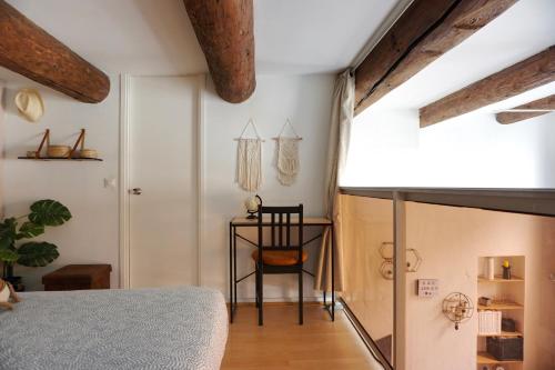 a bedroom with a bed and a table with a chair at Le Massilia de Steenia in Marseille