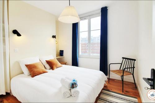 ein Schlafzimmer mit einem weißen Bett und Handtüchern darauf in der Unterkunft L'art de Vivre - Centre Historique - Coup de Cœur in Le Havre