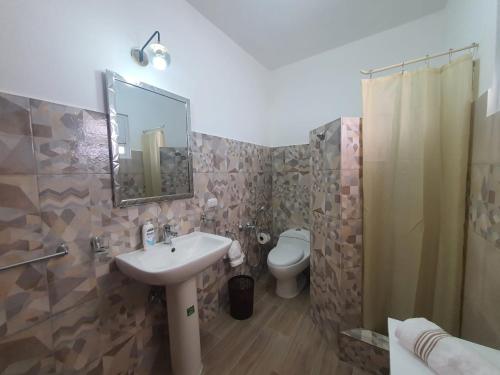 a bathroom with a sink and a toilet and a mirror at Apartamento bayahibe in Bayahibe