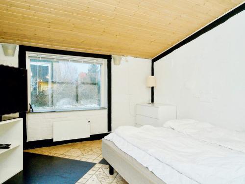 1 dormitorio con cama y ventana en Holiday home Jægerspris XXIII, en Jægerspris
