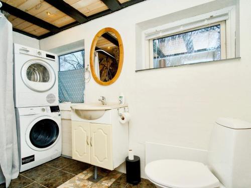 a bathroom with a washing machine and a washer and dryer at Holiday home Jægerspris XXIII in Jægerspris
