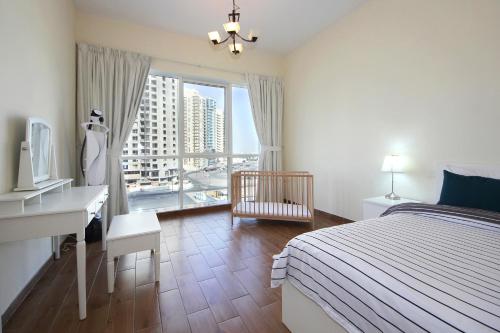 1 dormitorio con cama, escritorio y ventana en THE 407 Room, en Dubái