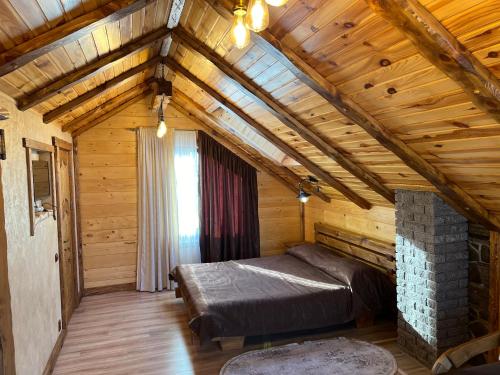 sypialnia z łóżkiem w drewnianym domku w obiekcie Цісарка w mieście Mikuliczyn