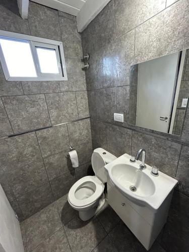a bathroom with a toilet and a sink and a mirror at DEPARTAMENTO CÉNTRICO EN TANDIL in Tandil