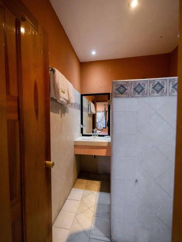 a small bathroom with a shower and a sink at Hotel el Ángel Taxco in Taxco de Alarcón