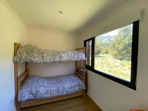 a bedroom with two bunk beds and a window at Meliquina Home in Villa Meliquina