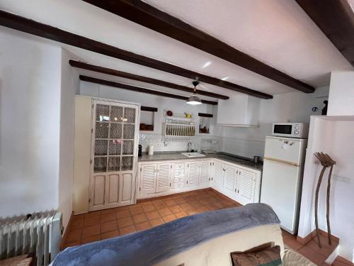 a kitchen with white cabinets and a white refrigerator at Romeral 1 in Alájar
