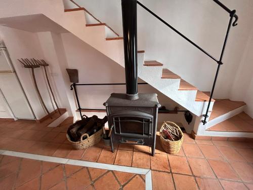 a stove in a living room with a staircase at Romeral 1 in Alájar
