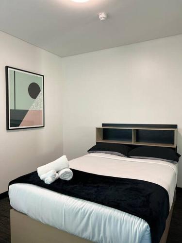 1 dormitorio con 1 cama grande y 2 toallas. en entire 2BR Central Apt 1004, en Adelaida