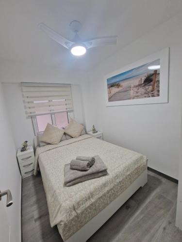 Un dormitorio con una cama con dos toallas encima. en Piso vacacional, en Calpe