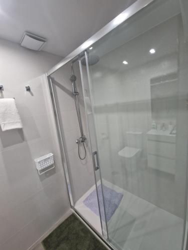 una ducha con puerta de cristal en un baño en Piso vacacional, en Calpe